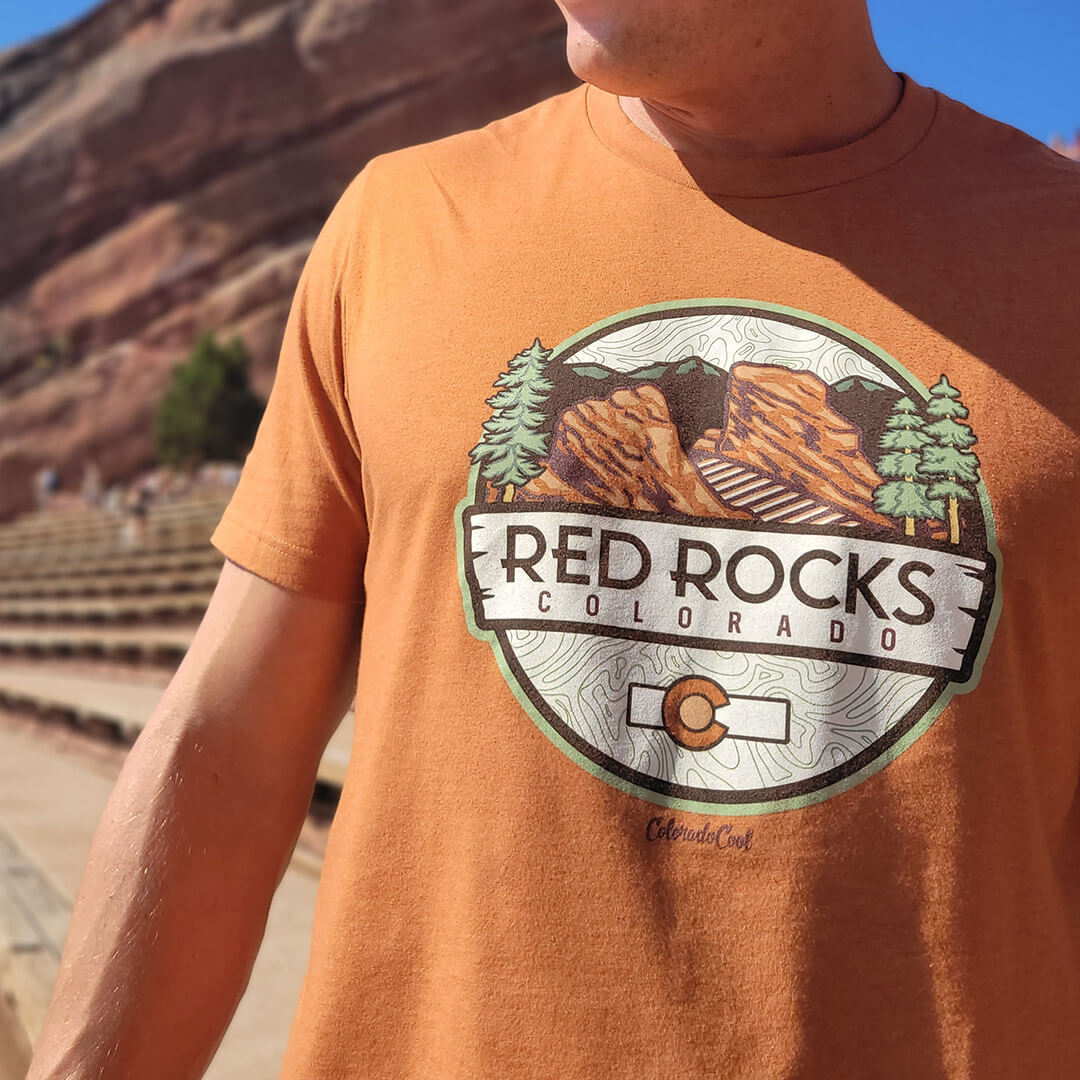 Man wearing Red Rocks graphic t-shirt in front of the iconic red rocks venue in Morrison, Colorado